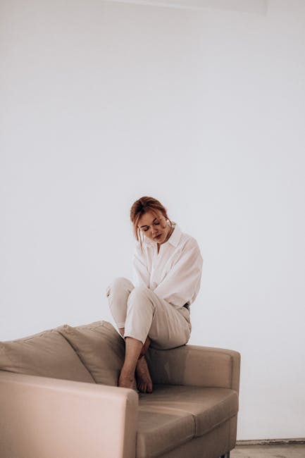 Elegant woman in a relaxed yoga pose in a beautifully lit minimalist room.